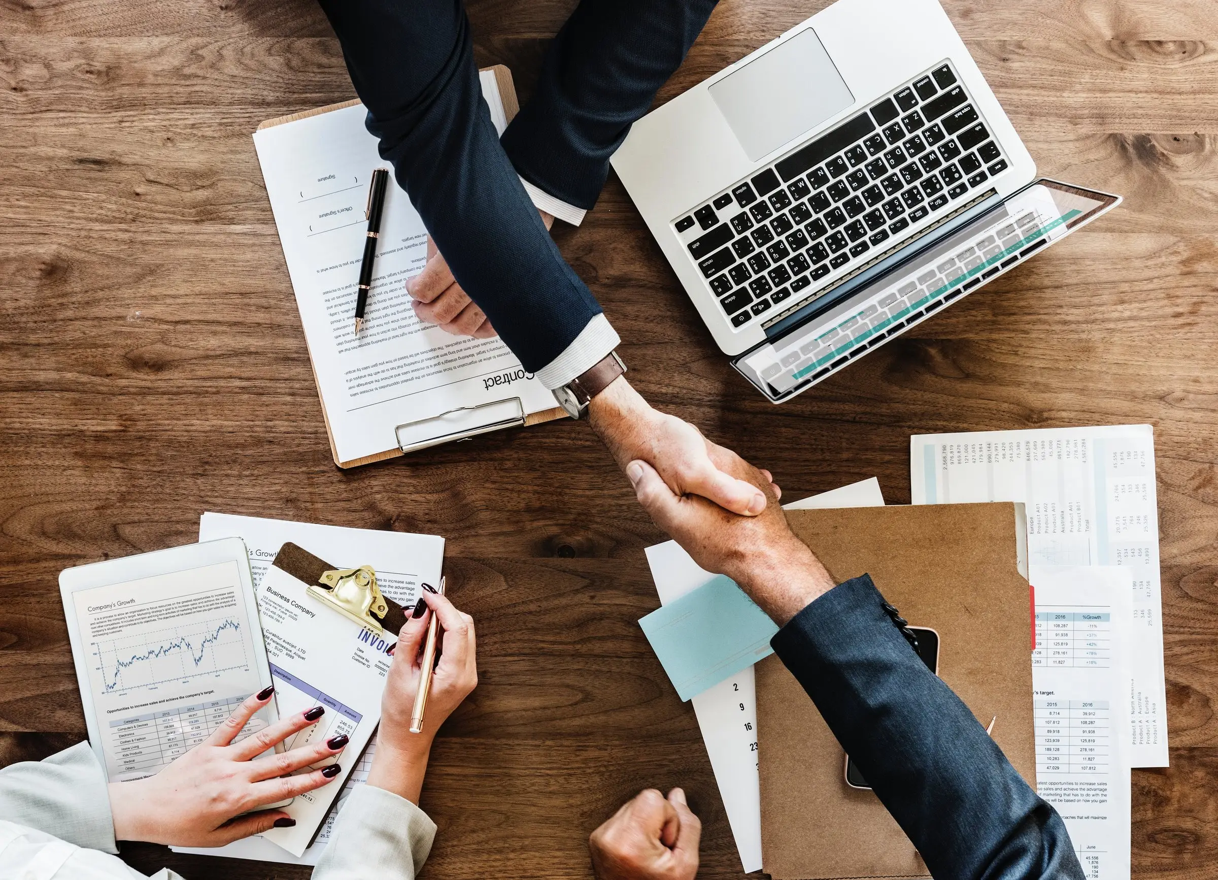 Business meeting with loan documents and a handshake