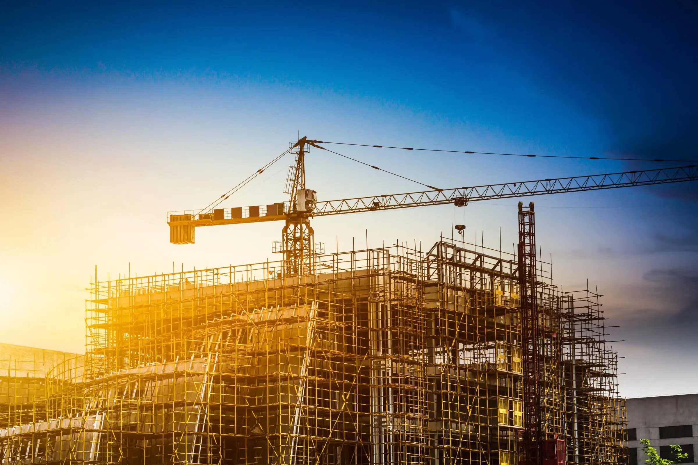 Construction site with a tower crane at sunset